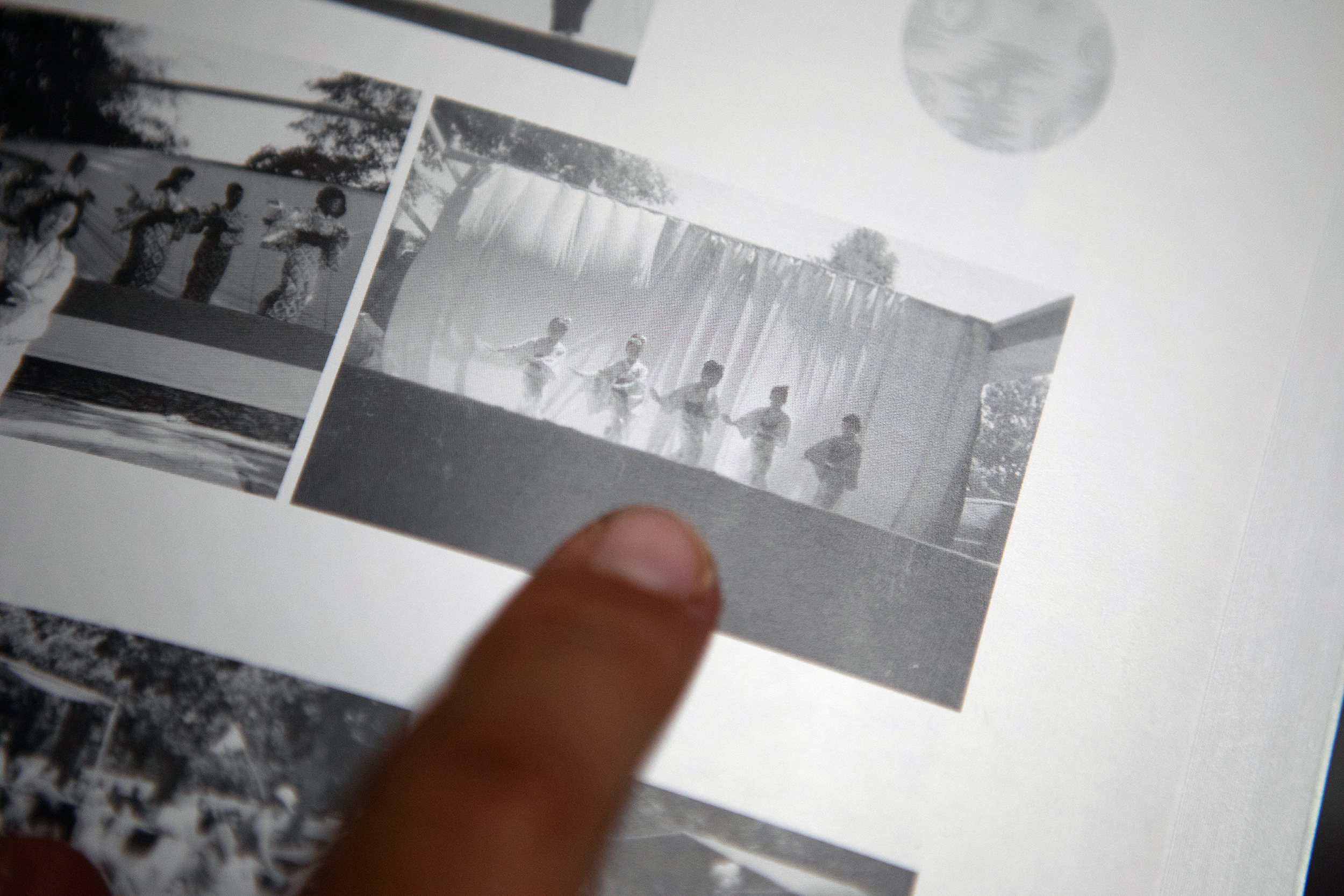 Finger pointing to a black and white photo of Okinawan dancers.